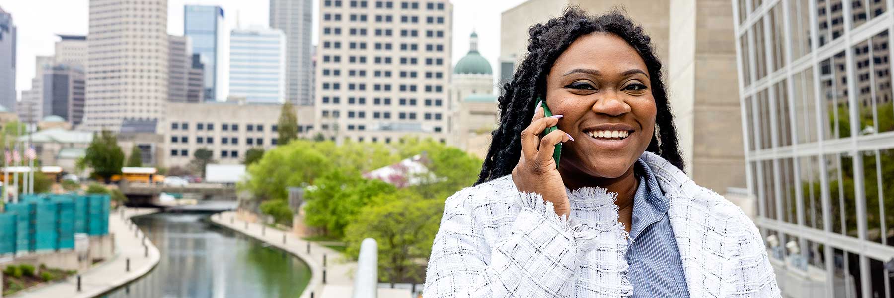 Student talks on phone outside with Indianapolis in the background