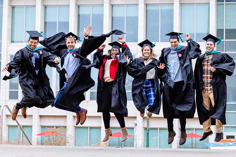 Grads in robes jump